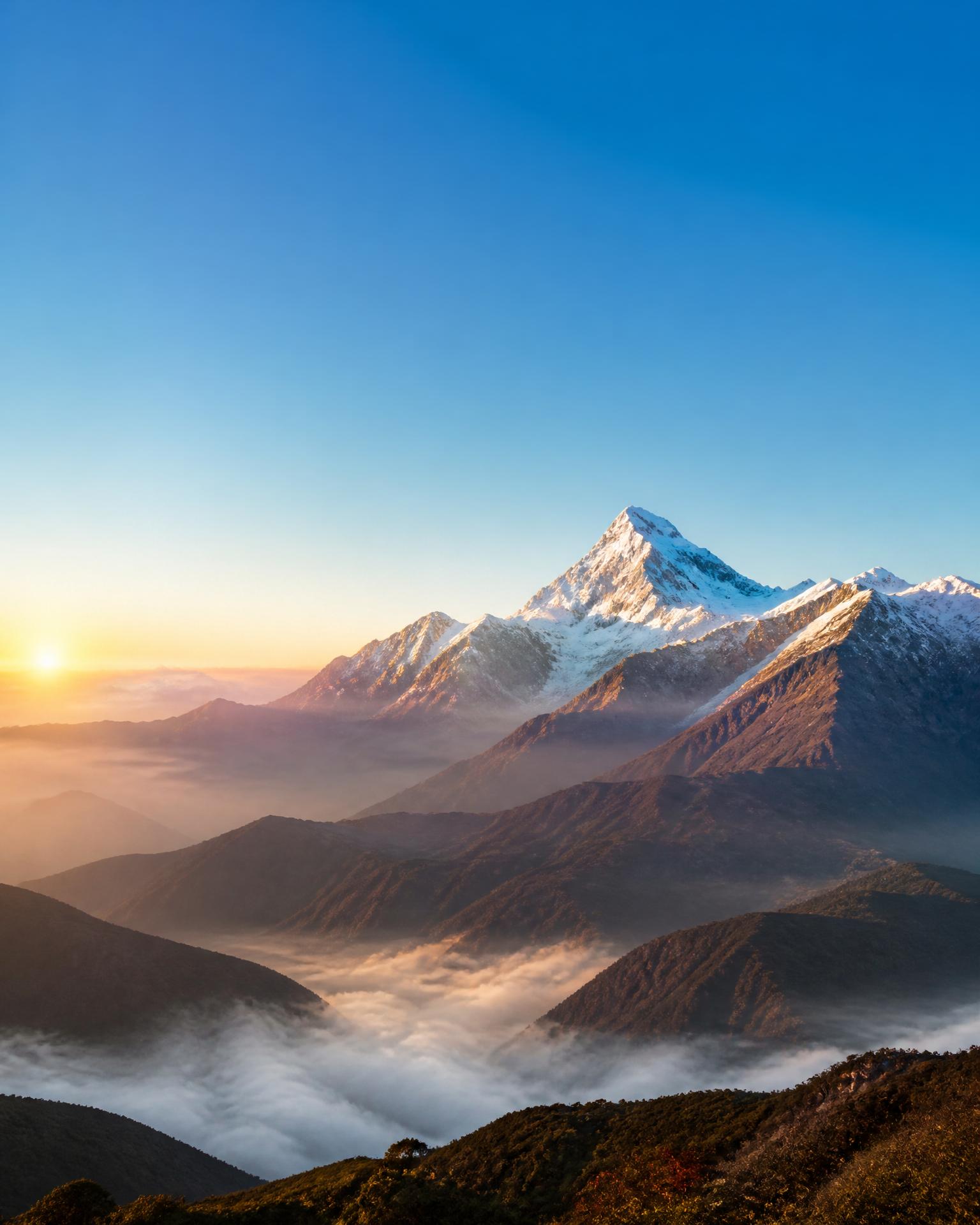 Sunrise breaking over misty mountains